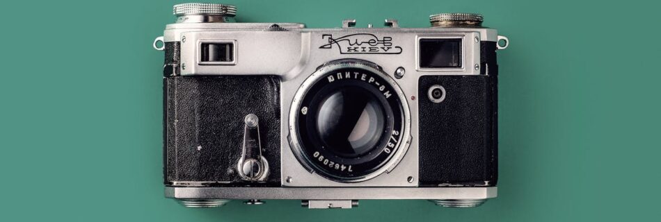 grey and black camera on green background